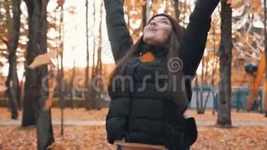 秋天公园里快乐的女人落叶。 秋天